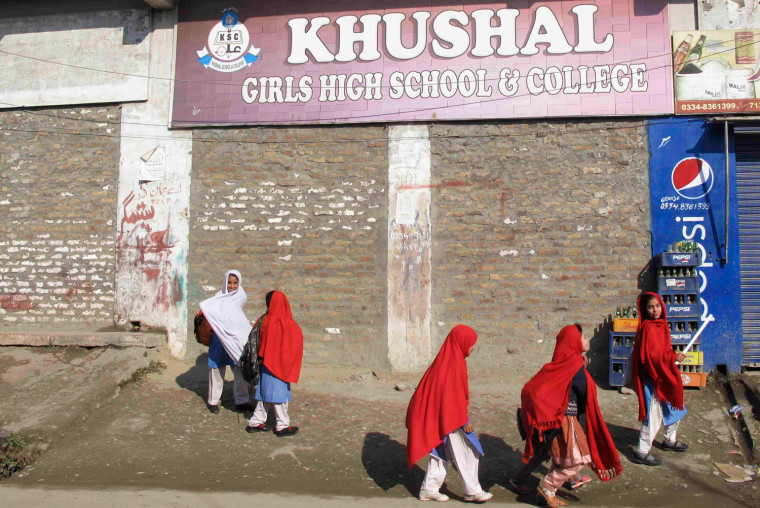 Image: School students walk past near Khushal School in Mingor